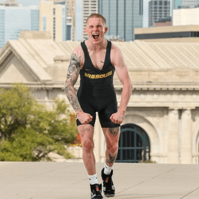 Picture of Noah Surtin in Missouri Wrestling Singlet flexing his muscles.