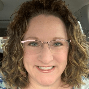 Woman smiling. Link redirects to landing page for Enrichment instructors.