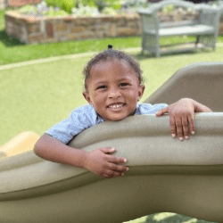 A girl playing on a slide at the Little Trojan Academy.
