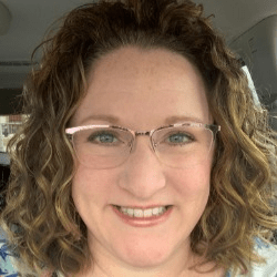 Charlotte Chalakee, a white woman with curly brown hair and glasses.