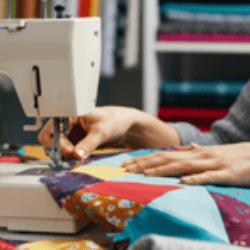 Hands using a sewing machine on a quilt top.