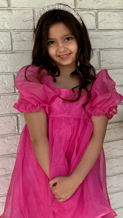 Kenna Marino, a girl with long brown hair in a pink dress.