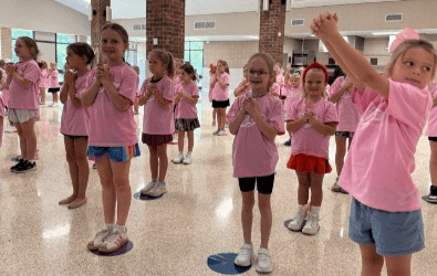 Girls from Pom and Cheer summer camp wearing matching shirts.