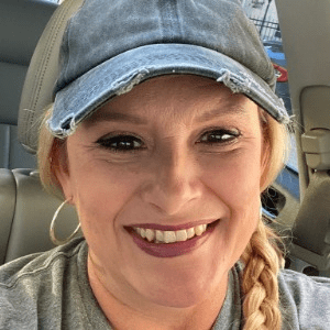 Debra Oakley, a white woman with braided blonde hair and a denim cap.