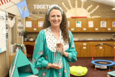 Kendall Ferguson, a teenage girl with long hair, wearing a Scouting USA uniform with neckerchief and merit badge sash.