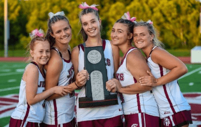 Five Jenks High School girls in lacrosse uniforms holding a Route 66 Champion trophy.