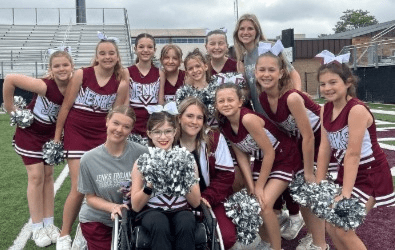 Pom and Cheer students posed in uniform on a field.
