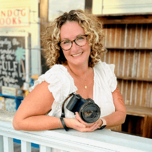 Holly Peevyhouse, a white woman with curly blonde hair, holding a camera.